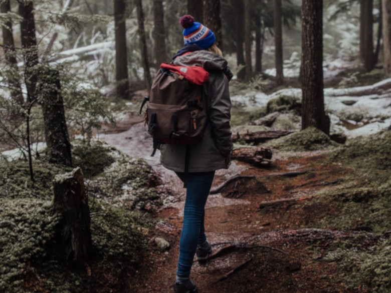 young woman going on a journey with her backpack in the woods