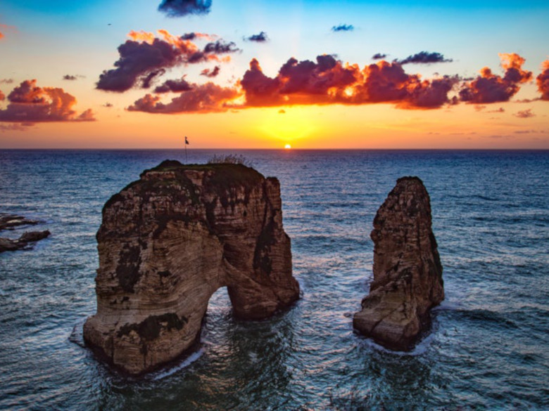 morning sunrise with beautiful clouds and mountainous rocks coming out of water