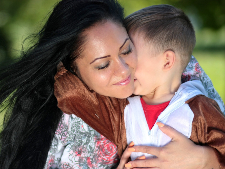 Mother lovingly hugging and kissing her child