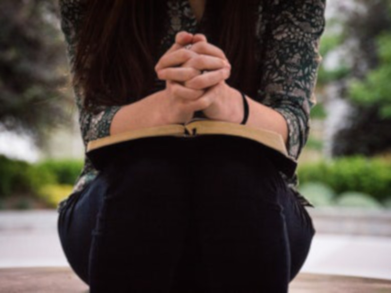 Woman with hands praying trying to forgive herself and others so she can move on