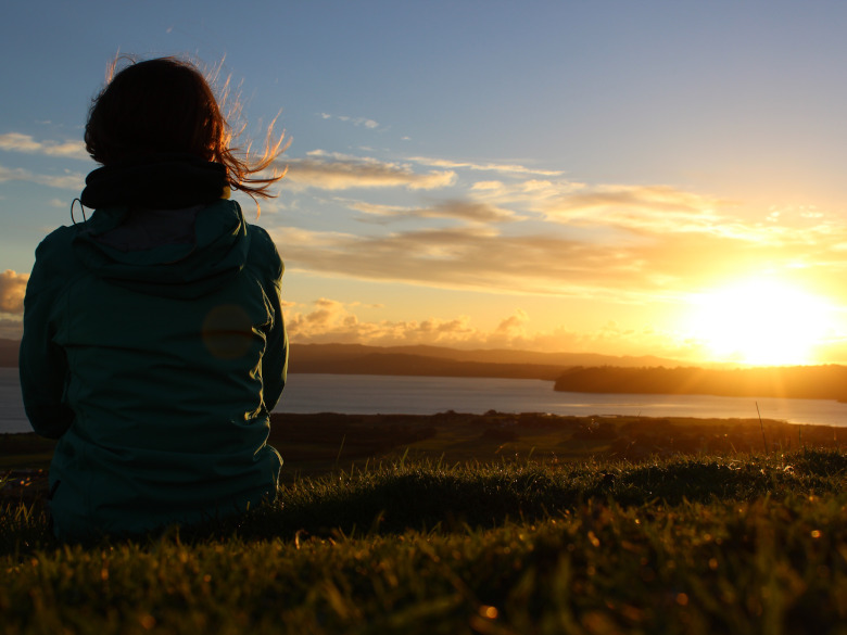 Girl peacefully looking at the sunset