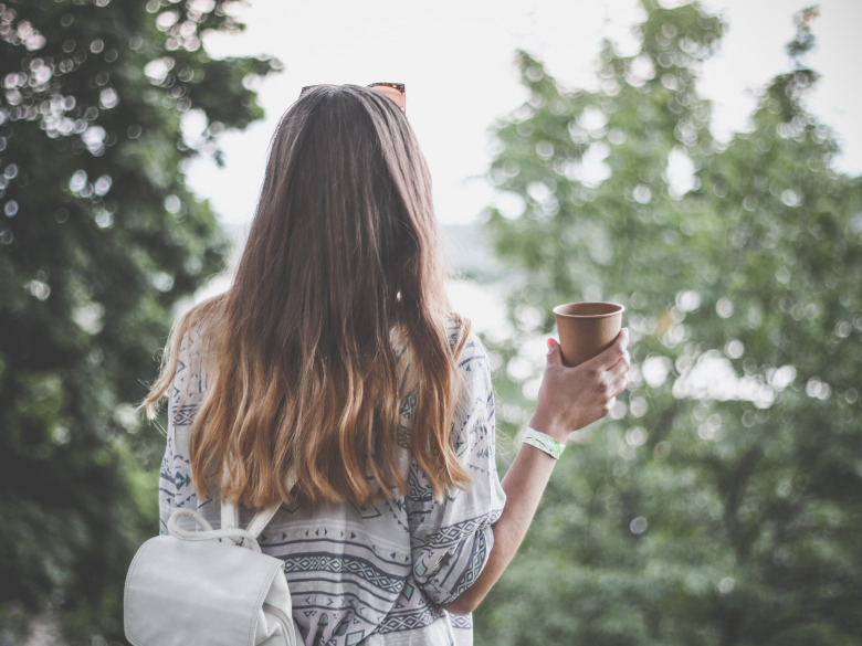 Woman looking ahead, with a backpack on appreciating what's in front of her