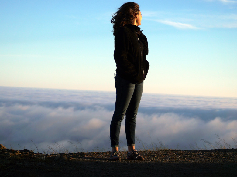 Woman standing on top of mountain