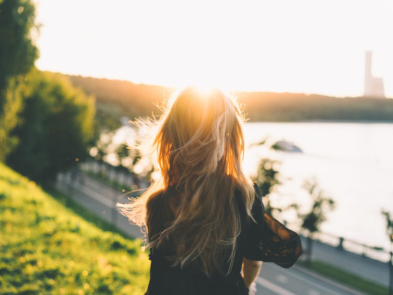 Peaceful girl in nature with bright sunlight