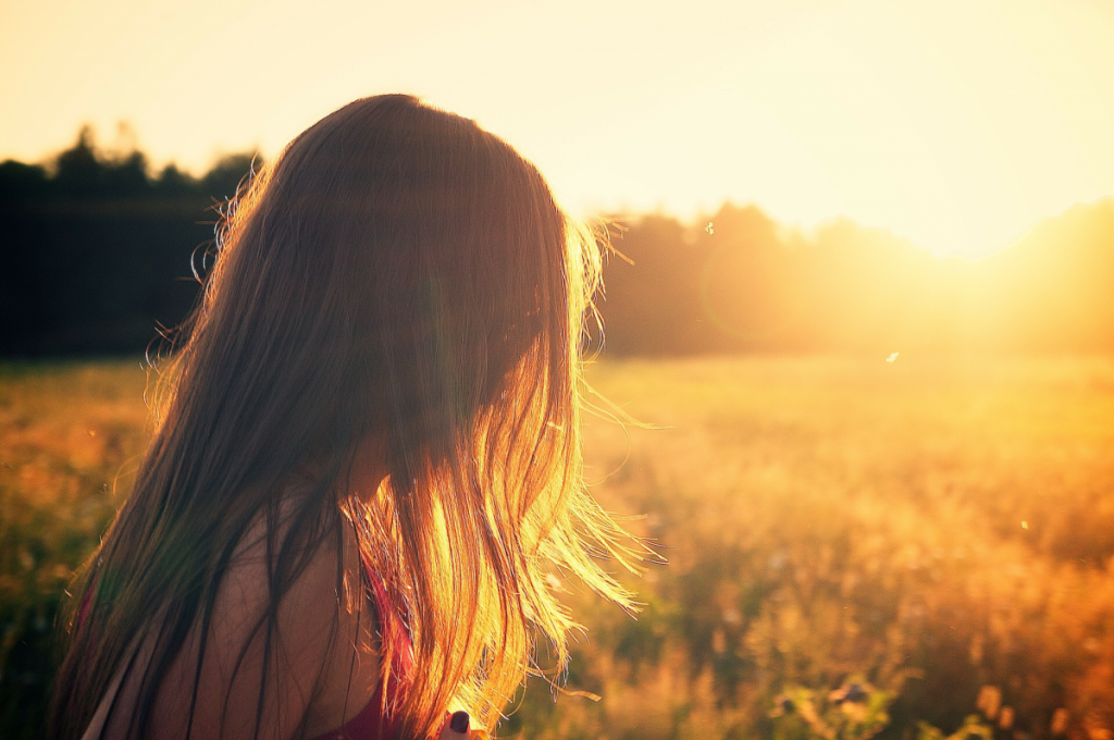 Sun shining in the field, beautiful woman long hair