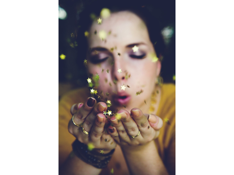 Woman making a wish blowing stars